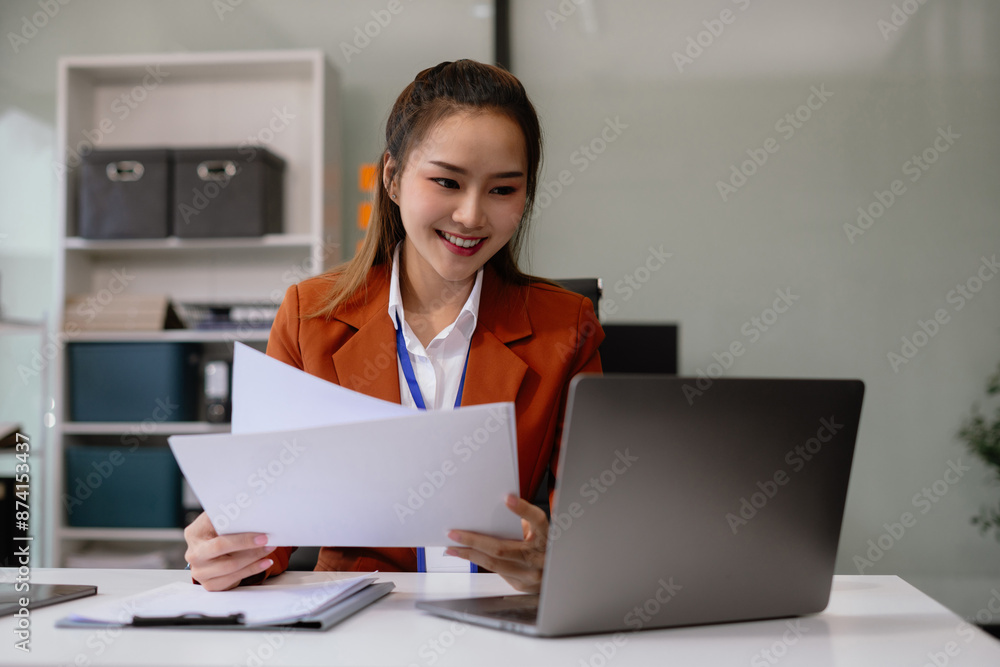 Business documents on the desk with a laptop and a Tablet with graphs, business diagrams and women working in the office. Business documents on the desk with a laptop and a Tablet with graphs, business diagrams and women working in the office.