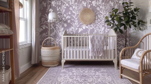 A white crib with a crocheted blanket sits in a nursery decorated with floral wallpaper and a woven rug. A wicker chair with a patterned cushion sits next to the crib.