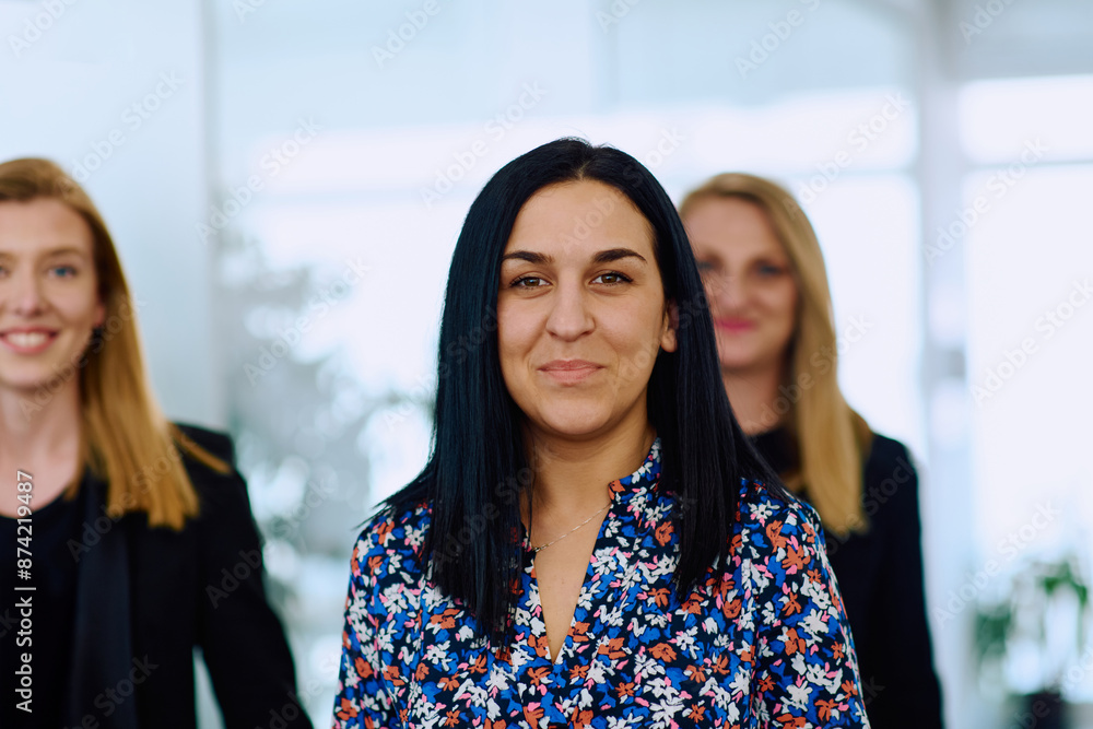 Fototapeta premium Confident businesswomen stride through the office hallway, deep in discussion.