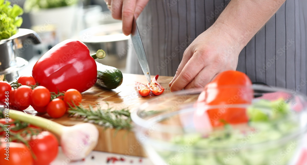 Close-up of male chef cutting hot pepper with sharp knife, veggies on cutting board, enjoy cooking. Person cook as hobby. Cooking, dish, homemade concept Close-up of male chef cutting hot pepper with sharp knife, veggies on cutting board, enjoy cooking. Person cook as hobby. Cooking, dish, homemade concept