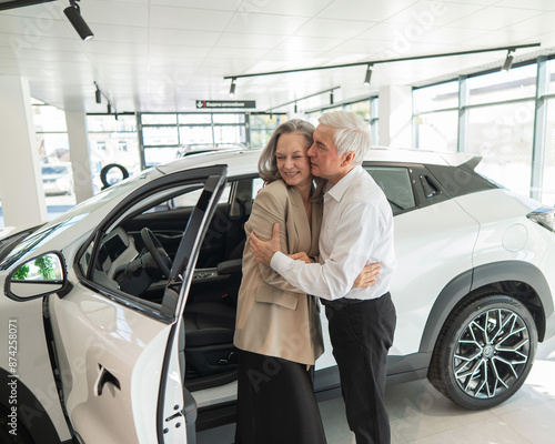Mature Caucasian couple hugging. Elderly man and woman buying a new car.  © Михаил Решетников