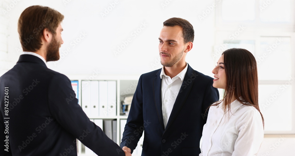 Portrait of couple shaking hands with realtor or lawyer, greet specialist in office. Appointment with consultation, qualified man. Help, advice concept Portrait of couple shaking hands with realtor or lawyer, greet specialist in office. Appointment with consultation, qualified man. Help, advice concept