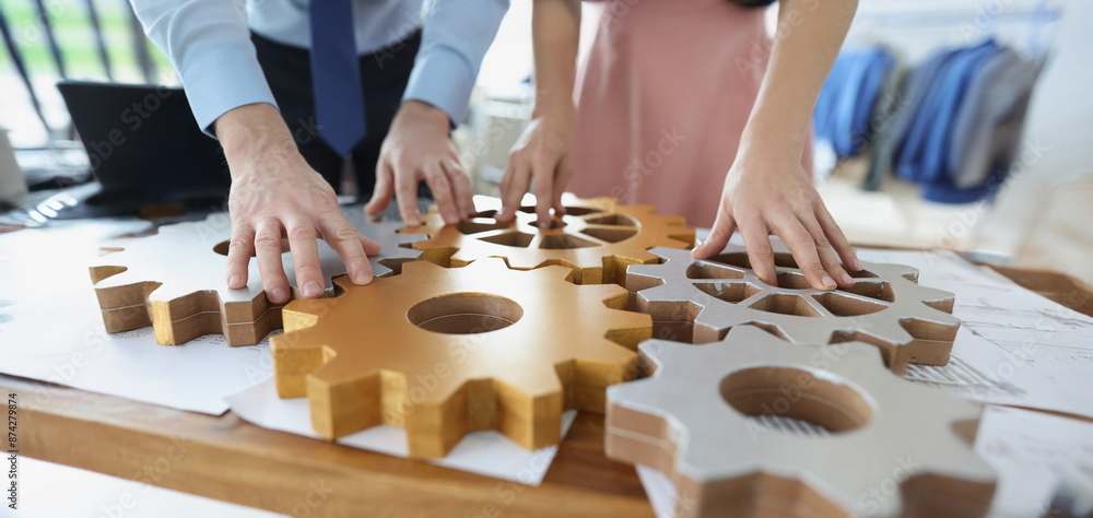 Close-up of businesspeople put wooden gears on workplace together, work in team. Teamwork, cooperation, successful development, game, erudition concept