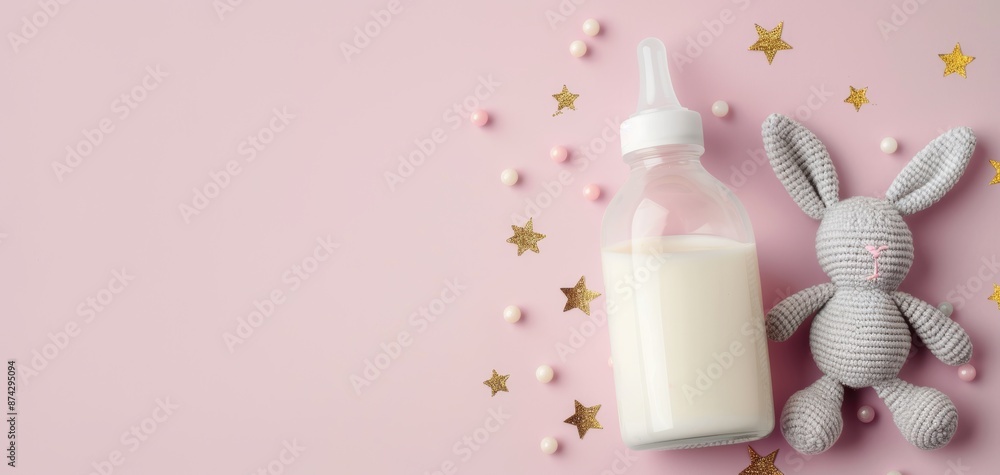 A bottle of milk is on a pink background with a stuffed rabbit A bottle of milk is on a pink background with a stuffed rabbit
