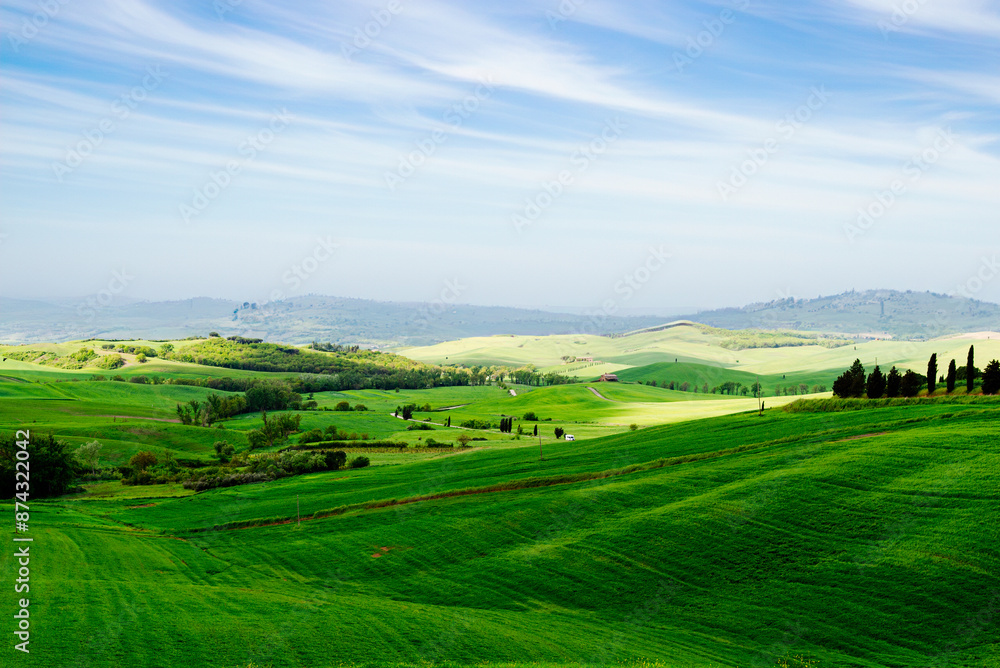 Tuscany, Italy-April 22, 2024: Expansive Green Tuscan Hills Under Blue Sky Tuscany, Italy-April 22, 2024: Expansive Green Tuscan Hills Under Blue Sky