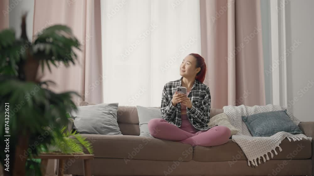 Asian lady surfing internet by smartphone and chatting online, portrait at home. Young Japanese or Chinese woman communicating in social media by mobile phone, internet addiction, overuse of gadgets Asian lady surfing internet by smartphone and chatting online, portrait at home. Young Japanese or Chinese woman communicating in social media by mobile phone, internet addiction, overuse of gadgets