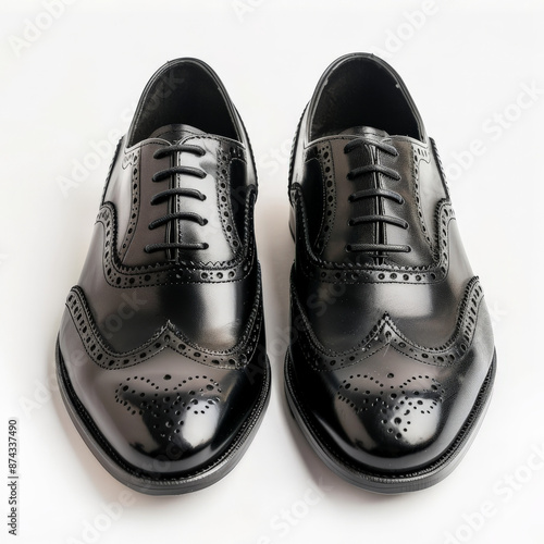 Classic black leather wingtips with brogue detailing, isolated on white background.