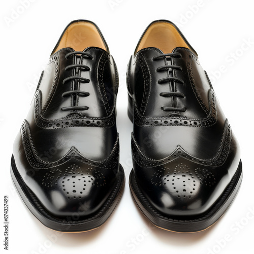 Classic black leather wingtips with brogue detailing, isolated on white background.