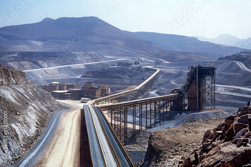 Conveyor belts transporting phosphate from an open pit mine to a processing plant in a mountainous landscape