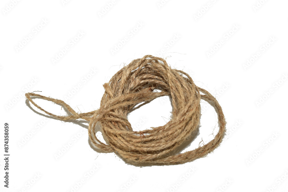 A skein of twine made from natural fibers lies on a white background. A skein of twine made from natural fibers lies on a white background.