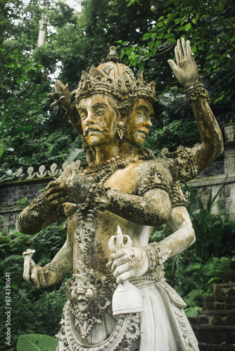 Four arm statue in Tirta gangga water palace in Bali. Peaceful Asian religion photo