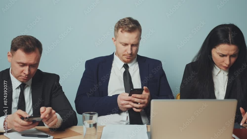 Business team members use their break to engage with their smartphones, highlighting mobile dependency and digital addiction in workplace Business team members use their break to engage with their smartphones, highlighting mobile dependency and digital addiction in workplace