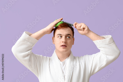 Young man using hair scalp ...