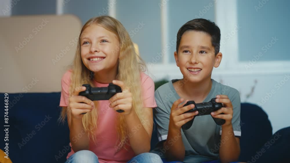 Happy boy and girl playing online video game using gamepads, kids hobby Happy boy and girl playing online video game using gamepads, kids hobby
