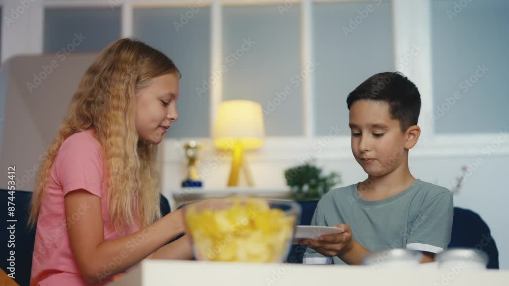 Pre-teen boy sharing pizza with his friend, children enjoying food at home Pre-teen boy sharing pizza with his friend, children enjoying food at home