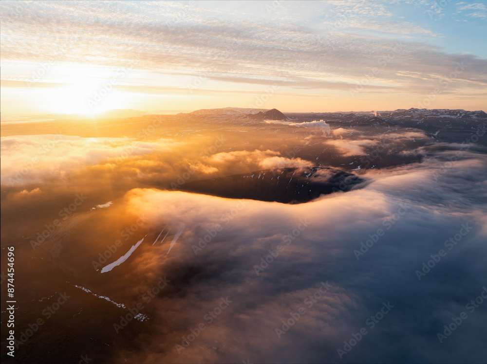 View from above, stunning aerial view of Hverfjall volgano at sunset surrounded by beautiful fluffy clouds. Hverfjall is a fascinating volcano near Lake Mývatn, with a crater approximately 1 km wide.