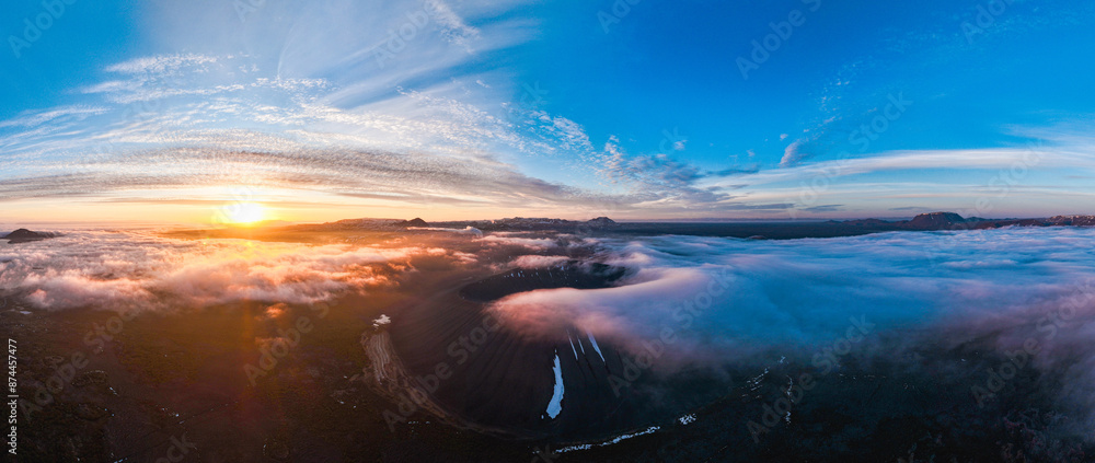 View from above, stunning aerial view of Hverfjall volgano at sunset surrounded by beautiful fluffy clouds. Hverfjall is a fascinating volcano near Lake Mývatn, with a crater approximately 1 km wide.