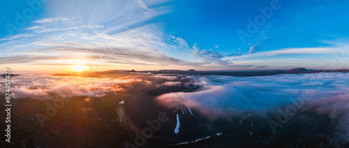 Obraz na płótnie View from above, stunning aerial view of Hverfjall volgano at sunset surrounded by beautiful fluffy clouds. Hverfjall is a fascinating volcano near Lake Mývatn, with a crater approximately 1 km wide. w salonie
