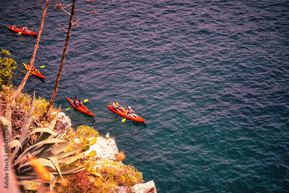 Amalfi, Italy - June 24, 2024: Aerial View of bunch of Kayaker on Clear Waters, Top-down perspective of a kayaker in a red kayak or canoe boats navigating the crystalline blue waters of Mediterranean