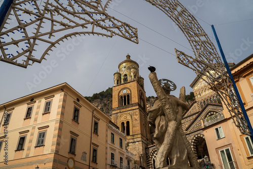 Obraz na płótnie Rear view of a fountain statue located in the center of Amalfi against Cathedral bell tower in Amalfi, Italy. The church of the Apostle Saint Andrew, Roman Catholic church in the Piazza del Duomo w salonie