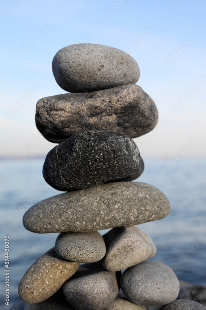 Φωτογραφία stack of stones on beach, Balanced pebble pyramid silhouette on beach with ocean in background, Zen stones on the sea beach, meditation, spa, harmony, calmness, balance concept, blur background