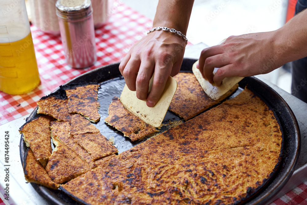 Socca, just coming out of the oven, in Nice, the French Riviera. a type of thin, Socca is a specialty of southeastern French cuisine. a pancake made from chickpea flour.