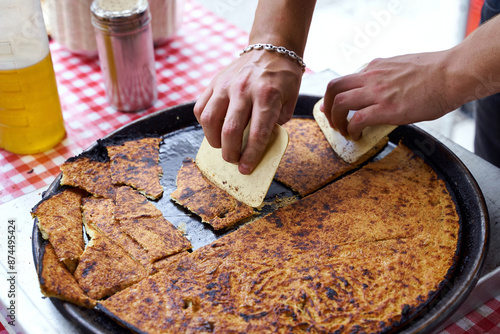 Obraz na płótnie Socca, just coming out of the oven, in Nice, the French Riviera. a type of thin, Socca is a specialty of southeastern French cuisine. a pancake made from chickpea flour. w salonie