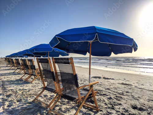 Row of blue beach chairs and umbrellas by the ocean on Hilton Head Island