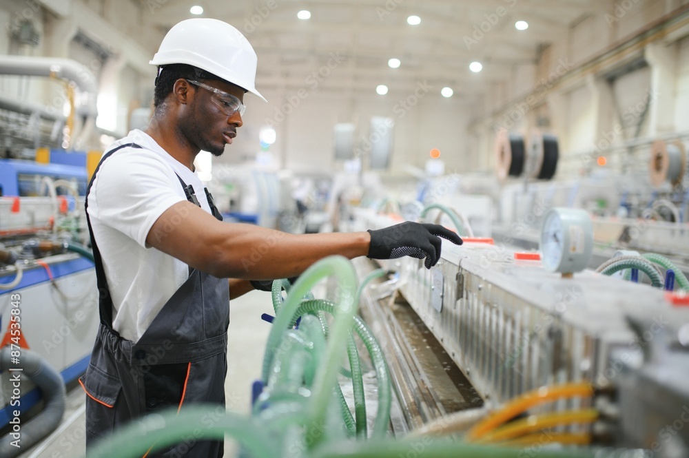 © Serhii - Portrait of industrial engineer. Smiling factory worker with hard hat standing in factory production line © Serhii - Portrait of industrial engineer. Smiling factory worker with hard hat standing in factory production line