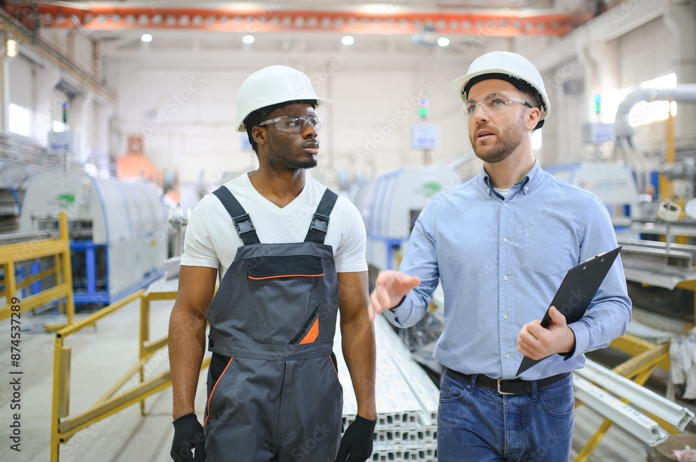 An engineer communicates with a worker on a production line An engineer communicates with a worker on a production line