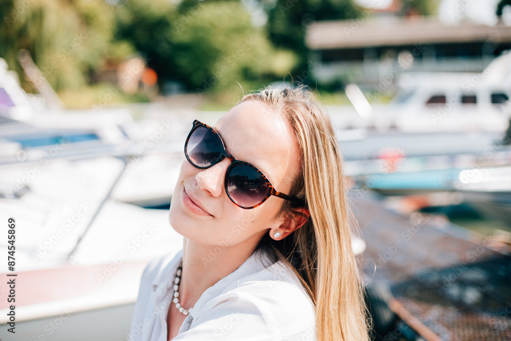 Woman in sunglasses on the beach.
Close up of a beautiful young girl enjoying the sun, on the dock by the river and looking at the camera Woman in sunglasses on the beach.
Close up of a beautiful young girl enjoying the sun, on the dock by the river and looking at the camera