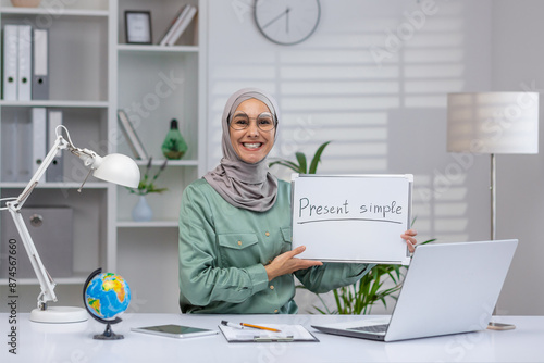Female teacher conducting an online class on present simple tense using a whiteboard