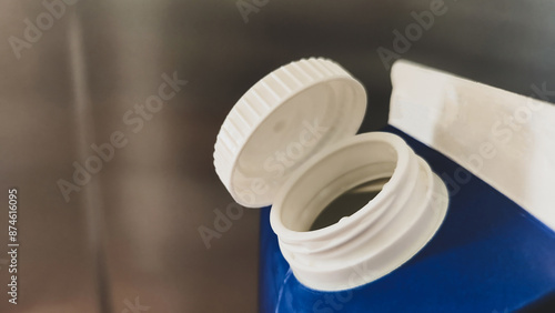 Open Blue Plastic Bottle Close-up. A detailed view of an open blue plastic bottle with a white cap, highlighting packaging design.