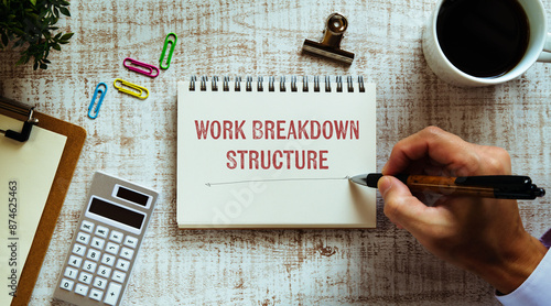 There is notebook with the word Work Breakdown Structure. It is as an eye-catching image.