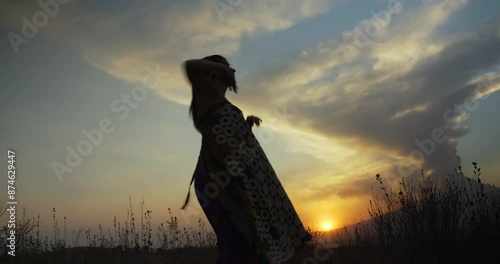 Silhouette of young mexican girl dancing free style in the countryyard with popocatepetl behind photo