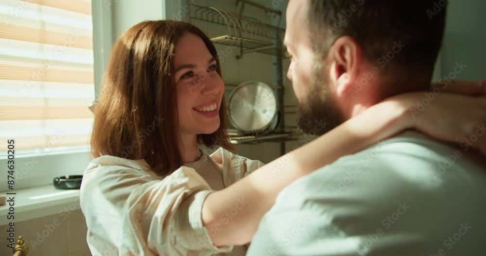 Happy brunette girl with a bob hairstyle in a plaid shirt communicates with her boyfriend in a white T-shirt while preparing breakfast and spending time together in the morning Happy brunette girl with a bob hairstyle in a plaid shirt communicates with her boyfriend in a white T-shirt while preparing breakfast and spending time together in the morning
