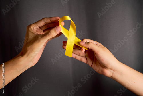 Female hand and male hand hold yellow lsiton. World Suicide Prevention Day Concept