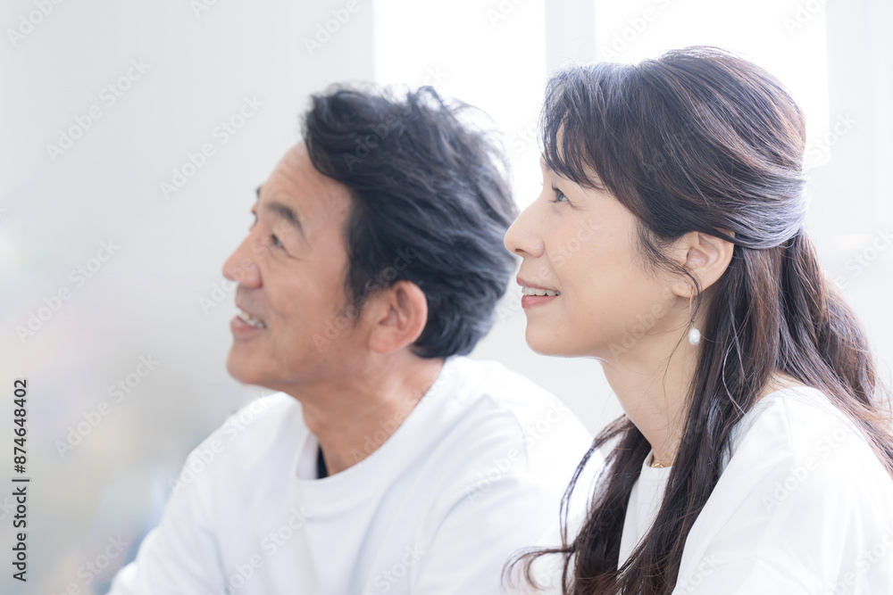 Close-up profile of a couple in their 50s looking up in the backlight Image of deciding something, future, goal, etc. Close-up profile of a couple in their 50s looking up in the backlight Image of deciding something, future, goal, etc.