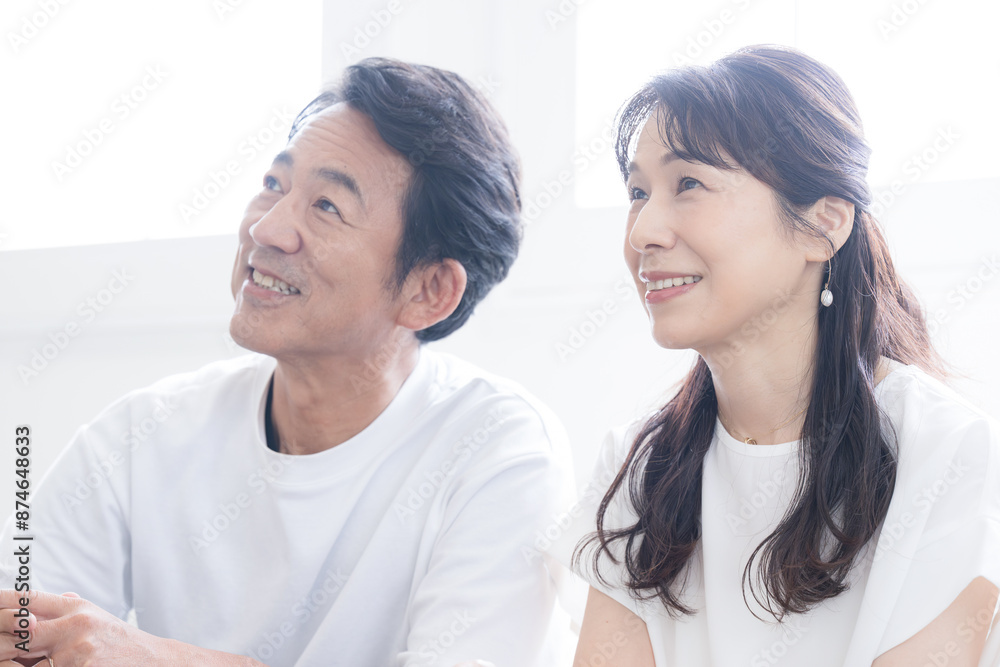 逆光の中見上げる50代の夫婦(カップル)のクローズアップの横顔 何かを決める、未来、目標などのイメージ 逆光の中見上げる50代の夫婦(カップル)のクローズアップの横顔 何かを決める、未来、目標などのイメージ