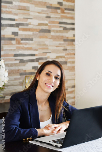 Ejecutiva de negocios trabajando en su computadora portátil en la oficina, toma vertical.