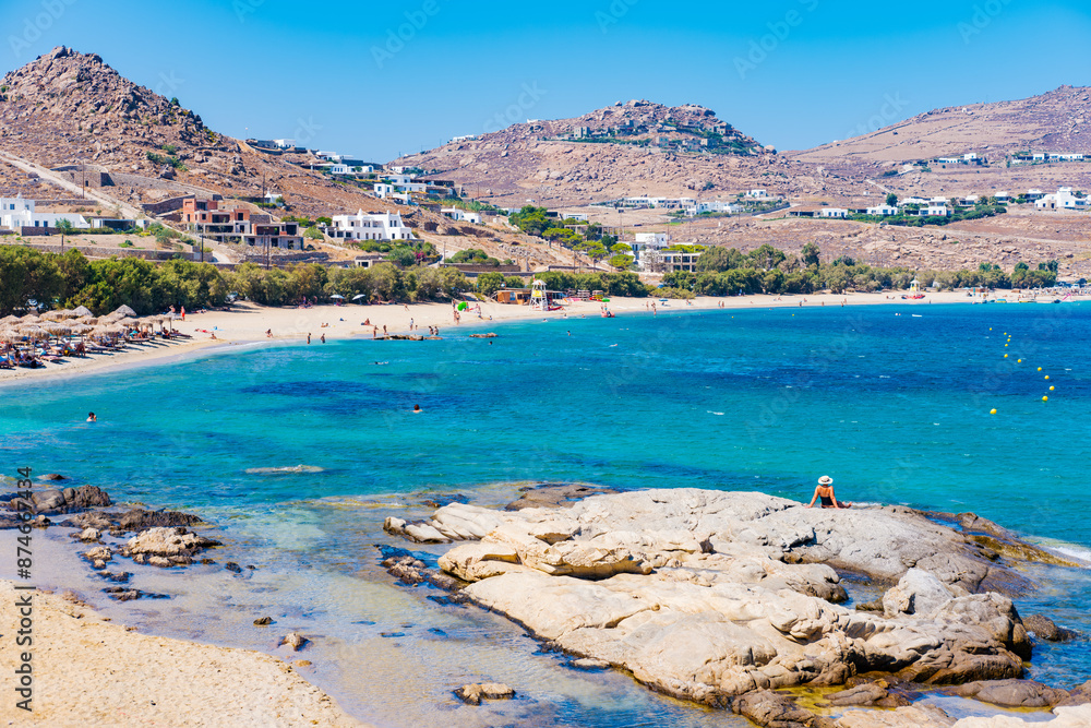 Naklejka premium Kalafatis Beach in Mykonos, Greece. Kalafati is the beach most loved for water sports such windsurf, kitesurf, diving and snorkeling. Near the awesome view of Dragnoisi Island and Divounia,