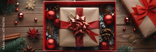 Exquisitely wrapped gift box with a red ribbon and bow, surrounded by festive ornaments and decorations, ready to be given as a present during the Christmas holiday season.