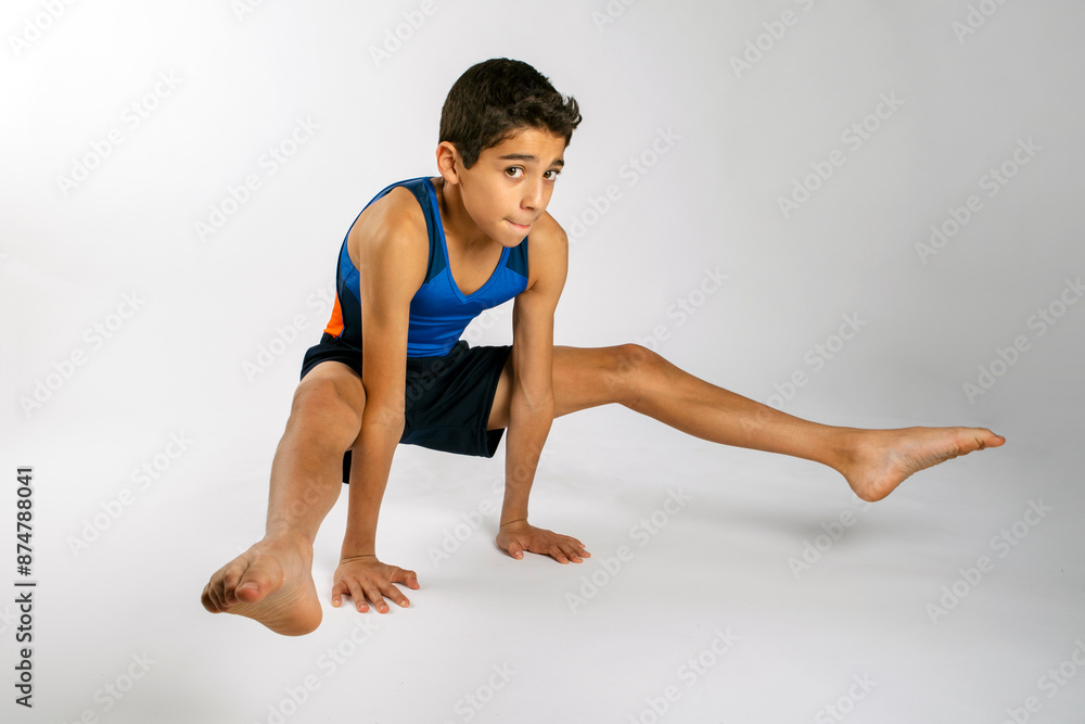 Male youth gymnast performing a floor exercise routine in his uniform singlet and shorts Male youth gymnast performing a floor exercise routine in his uniform singlet and shorts