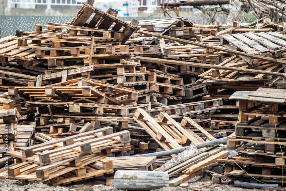 There are a lot of broken wooden pallets on the street. There are a lot of broken wooden pallets on the street.