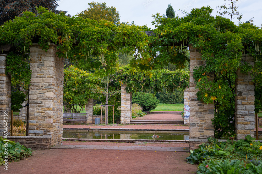 A beautiful park landscape with a stone brick pavilion and blooming plants. Autumn scenery of Nordpark, Dusseldorf, Germany. A beautiful park landscape with a stone brick pavilion and blooming plants. Autumn scenery of Nordpark, Dusseldorf, Germany.