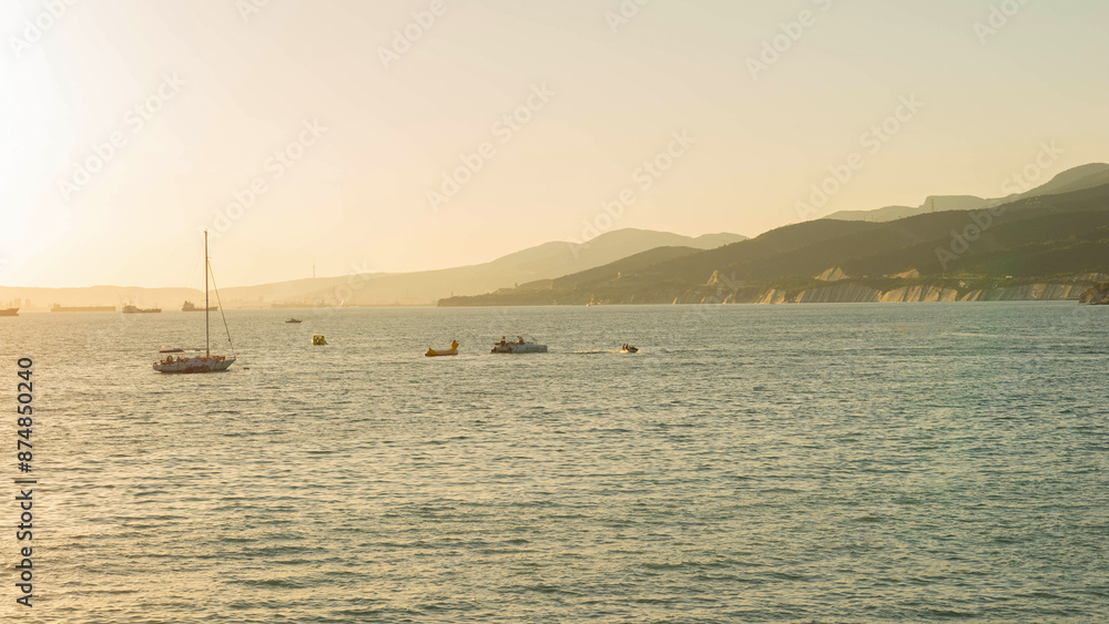 Tranquil Coastal Scene with Boats and Mountains at Sunset Tranquil Coastal Scene with Boats and Mountains at Sunset