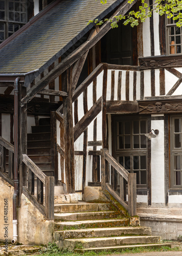 Entrée d'une maison à colombages avec escalier en pierre et poutres en bois