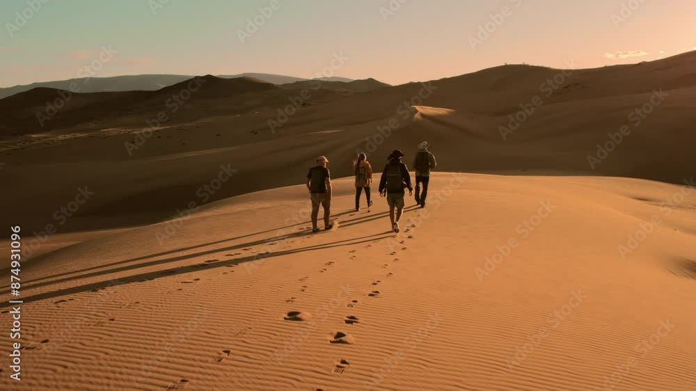 Four hikers or tourists with backpacks walks in sunset desert area Four hikers or tourists with backpacks walks in sunset desert area