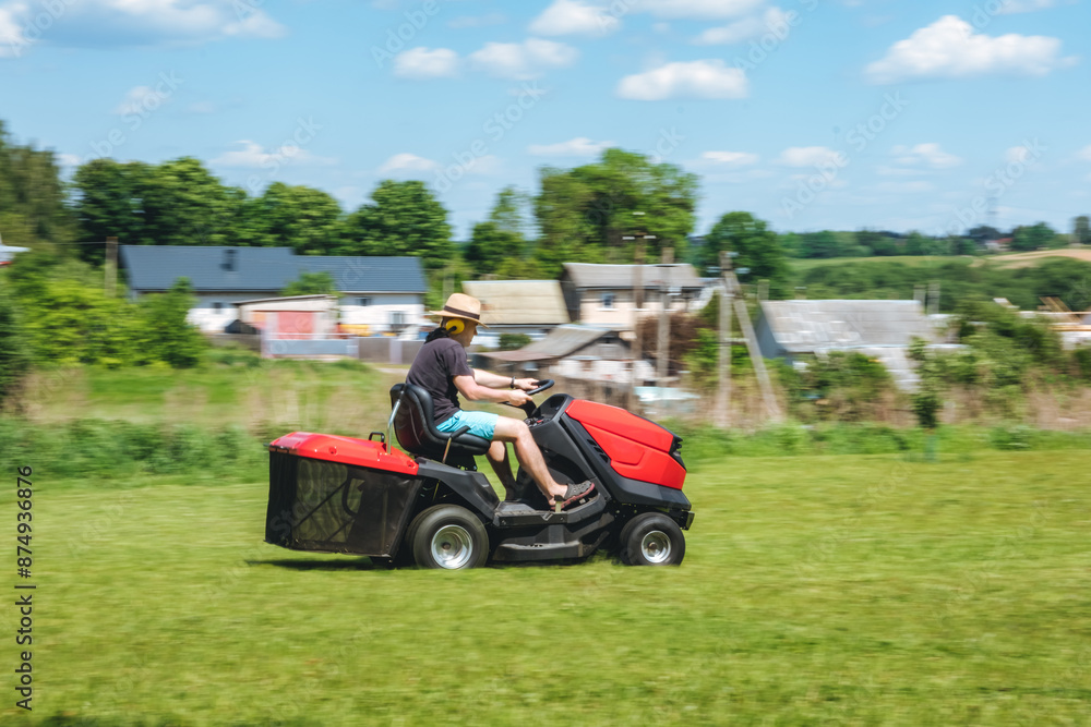 Man on lawn tractor mowing lawn on backyard. The red rider. The lawnmower tractor. High quality 4k footage Man on lawn tractor mowing lawn on backyard. The red rider. The lawnmower tractor. High quality 4k footage