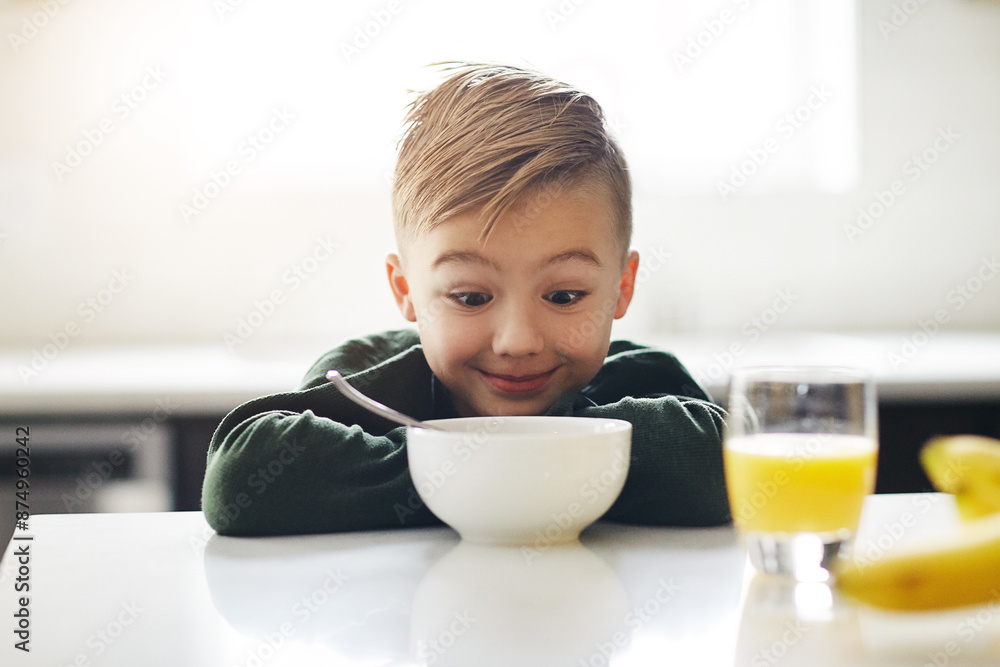 Excited, breakfast and kid in kitchen for morning, nutrition and health for development. Happy, child and bowl for cereal with orange juice for vitamins, growth and wellness on weekend in home Excited, breakfast and kid in kitchen for morning, nutrition and health for development. Happy, child and bowl for cereal with orange juice for vitamins, growth and wellness on weekend in home